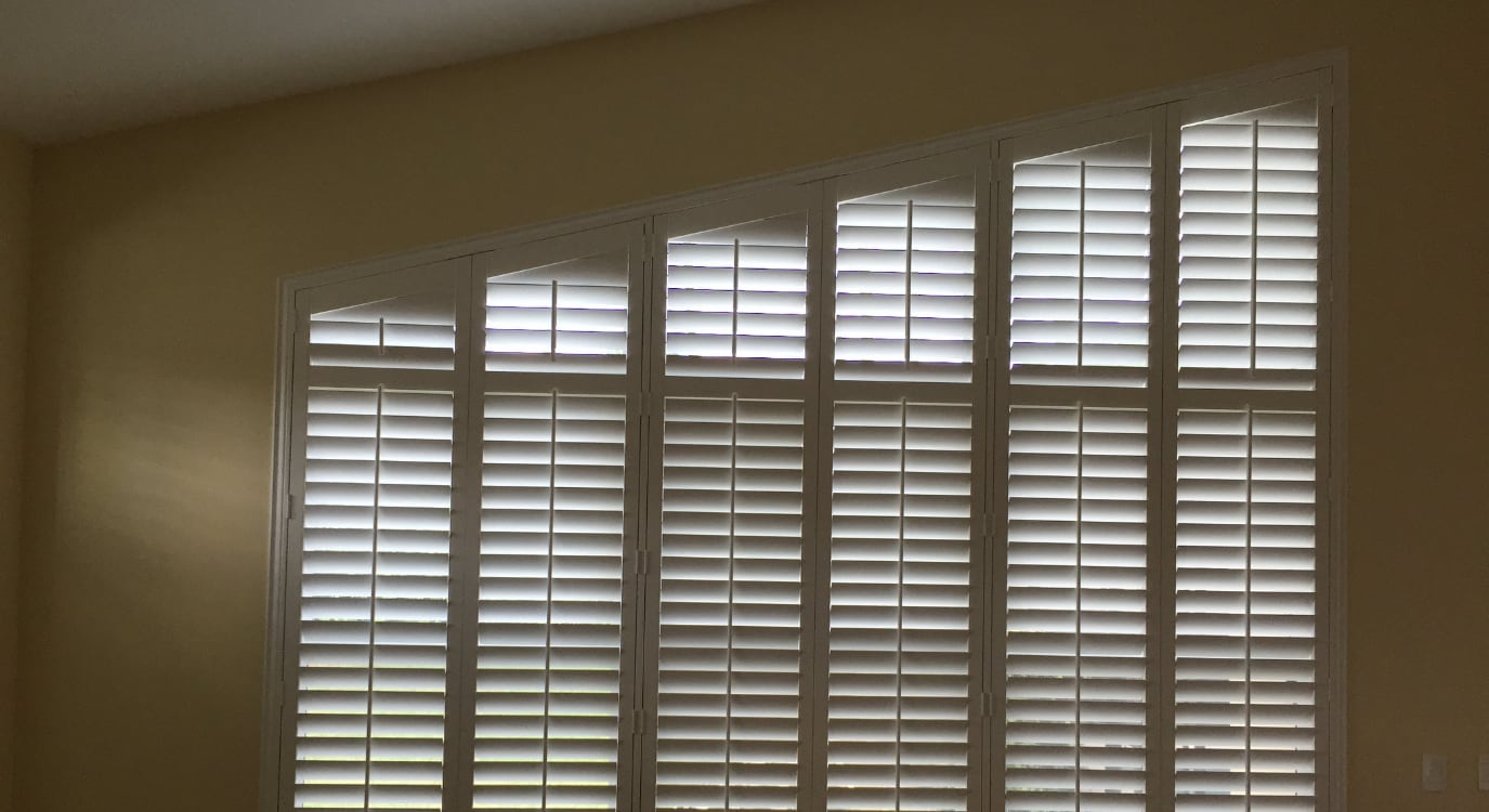 Plantation shutters on a high ceiling window